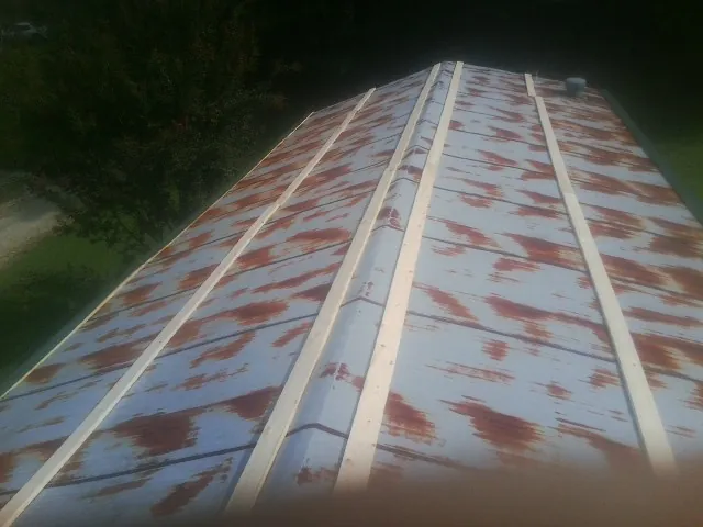 Rusted metal roof panels with new wood purlins before replacement — Storm Damage Roof Repair in Prinsburg by Roofing Brothers