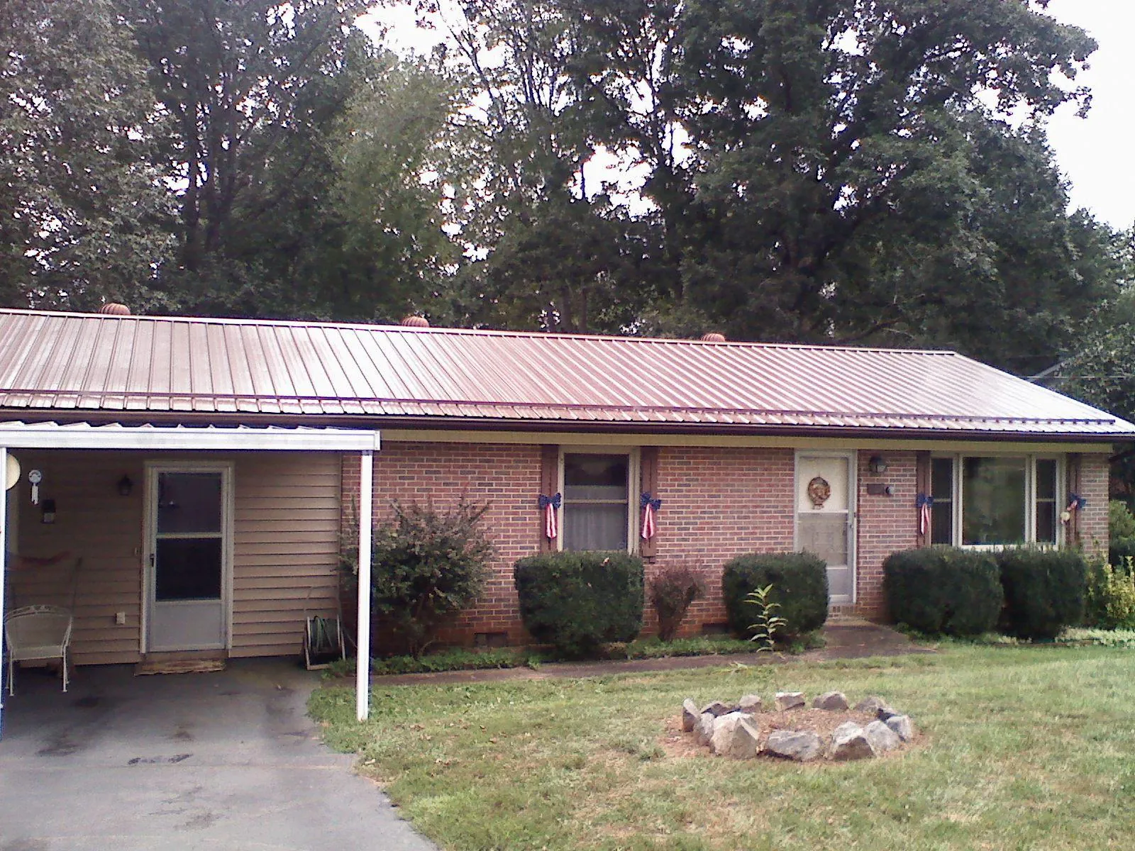 Bronze metal roof and carport on a brick ranch home — Roof Repair work by our crew in Prinsburg